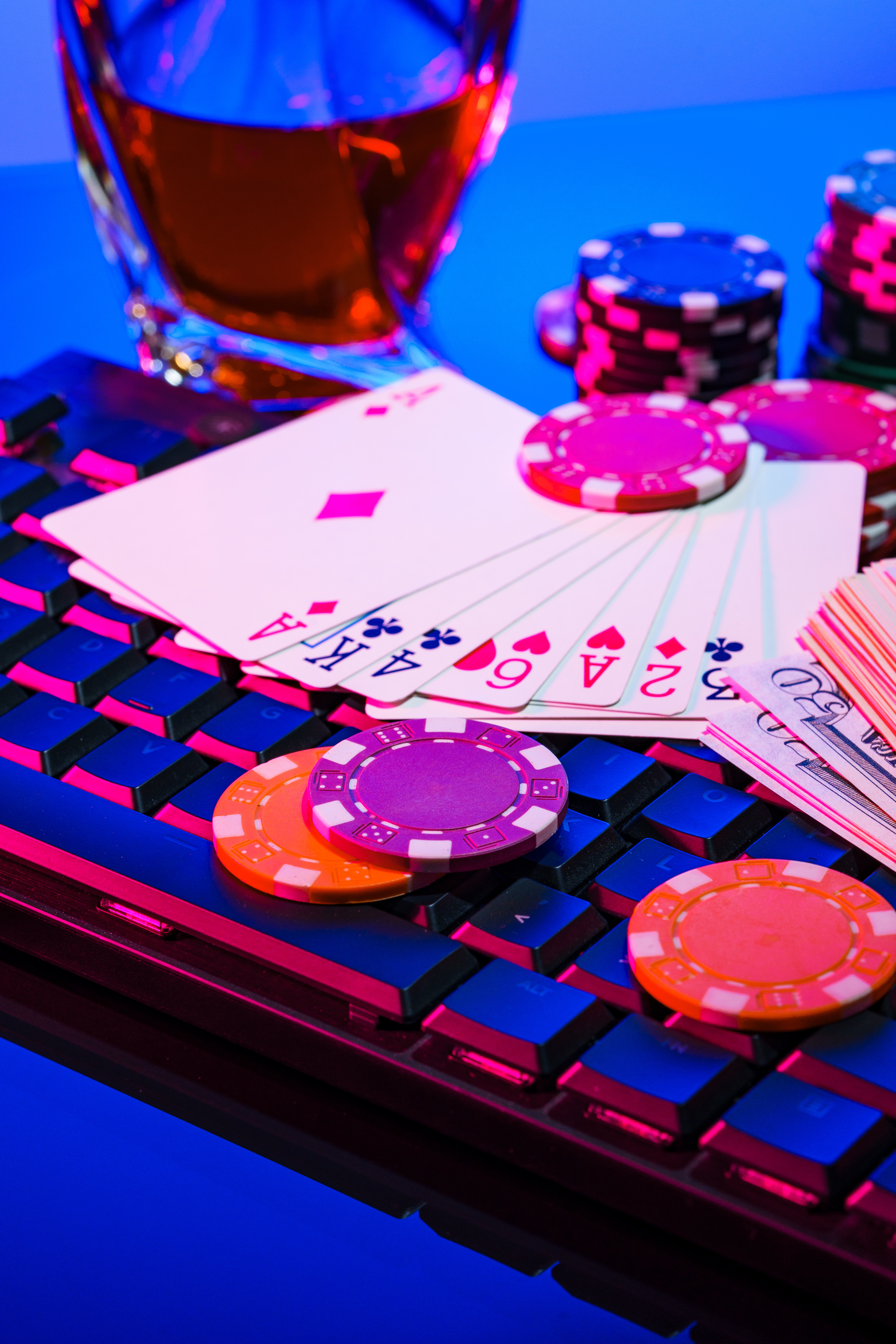 Game chips and cash on a dimly lit keyboard during an exciting gaming night at home